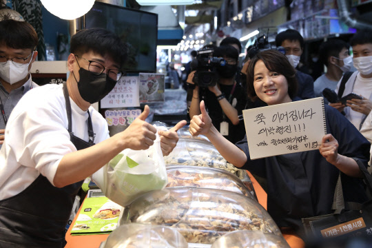 이영(오른쪽) 중기부 장관이 25일 서울 종로구 통인시장 내 손실보상금 수령 점포를 방문해 애로사항을 청취한 후, 상인들과 기념촬영을 하고 있다.  중기부 제공
